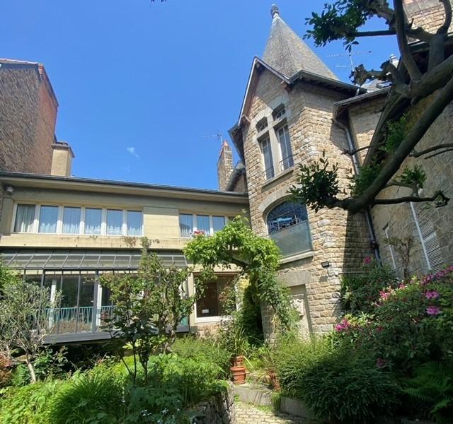 Maison de ville avec garage, nichée au fond d'un jardin ensoleillé.